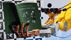 Ein Roboter am Lehrstuhl für Digitale Bildverarbeitung an der Fakultät für Mathematik und Informatik der Universität hält ein Buch in der künstlichen Hand